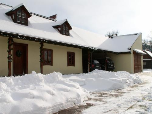 a house covered in snow in front of a house at Chalupa Alzbeta in Liptovský Ján