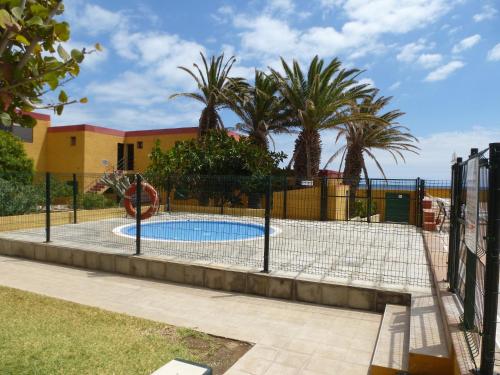 una valla alrededor de una piscina con parque infantil en Casa Agua y Sol II, en Porís de Abona
