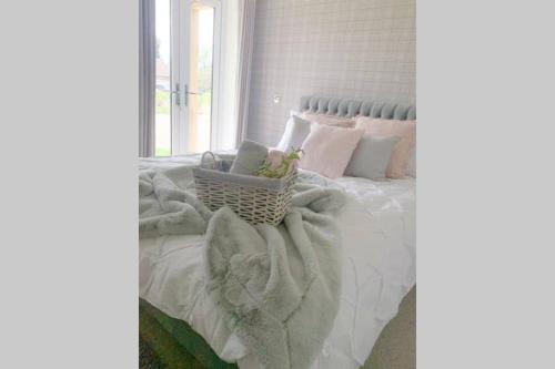 a bedroom with a white bed with a basket on it at Boundary Stable in Pickering