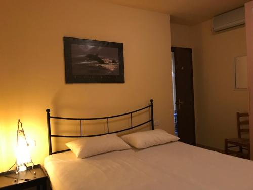 1 dormitorio con 1 cama con lámpara y una foto en la pared en Casa al mare, en Marina di Grosseto