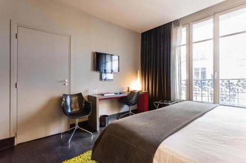 Habitación de hotel con cama, escritorio y ventana en CMG - Premium Tour Eiffel - 43, en París