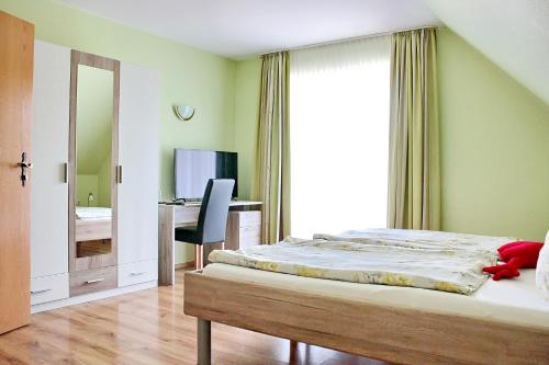 a bedroom with a bed and a desk and a mirror at Gasthaus Schadde in Vlotho