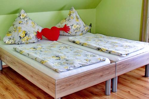 two twin beds in a room with a heart pillow at Gasthaus Schadde in Vlotho