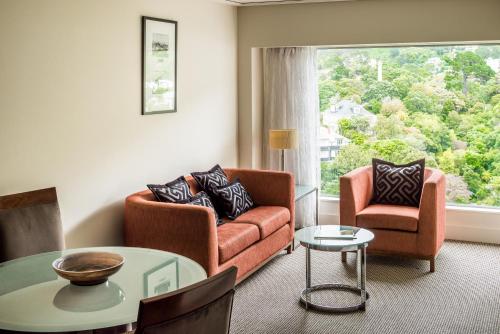 a living room with a couch and two chairs and a table at Bolton Hotel in Wellington