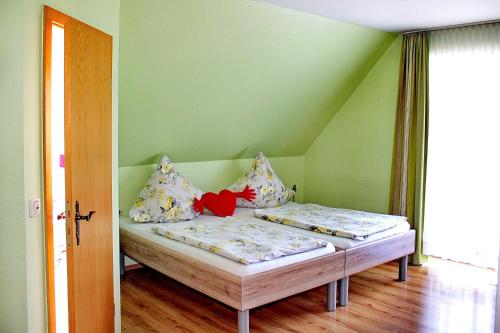 two beds in a room with green walls at Gasthaus Schadde in Vlotho