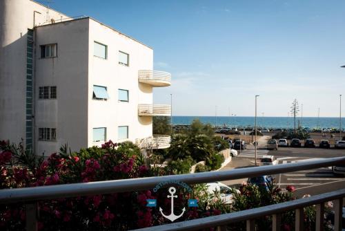 een balkon met een gebouw en de oceaan op de achtergrond bij Casa Vacanze Al Curvone in Lido di Ostia