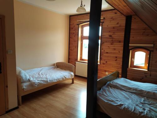 a bedroom with two beds in a log cabin at Wczasy na Kaszubach in Górki