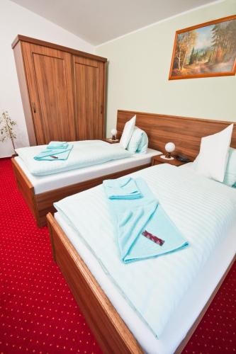 two beds in a hotel room with a towel on them at Spa Hotel Diana in Františkovy Lázně