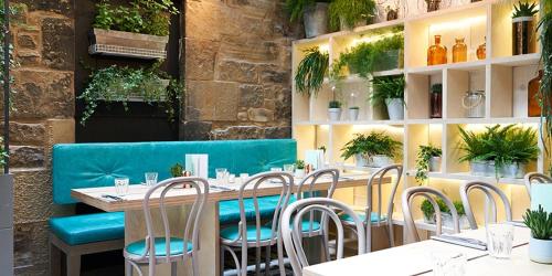 un restaurante con mesa, sillas y plantas en No. 53 Frederick Street, en Edimburgo