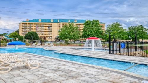 a swimming pool with a fountain in front of a building at Holiday Inn Express Hotel & Suites Pigeon Forge by IHG in Pigeon Forge