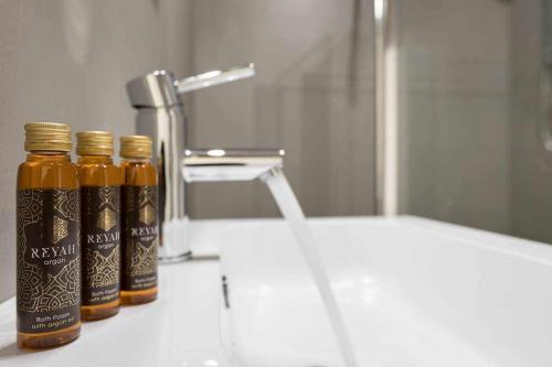 three bottles of honey sitting on a bathroom sink at La casina di Ivonne Arezzo Centro in Arezzo