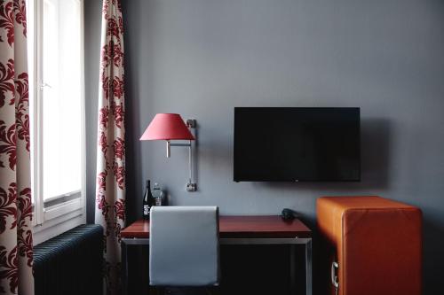 a room with a desk with a television and a chair at Hotel Weitzer Graz - Centre of Graz in Graz