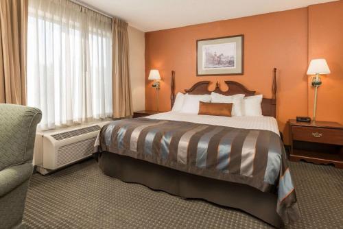 A bed or beds in a room at Wingate by Wyndham Airport - Rockville Road