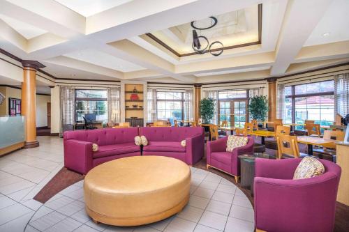 a waiting room with purple couches and tables at La Quinta by Wyndham Atlanta Ballpark/Galleria in Atlanta