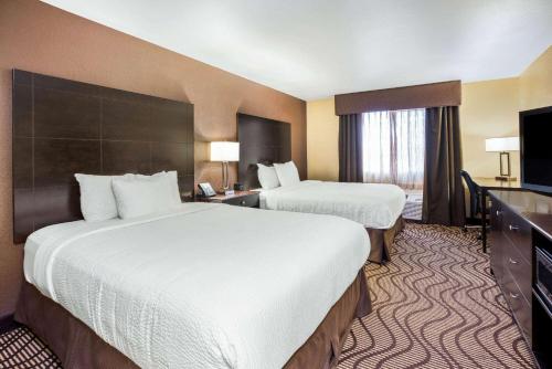 a hotel room with two beds and a television at La Quinta by Wyndham Meridian / Boise West in Meridian