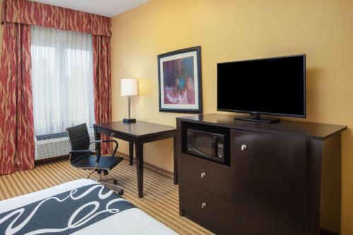 a hotel room with a television and a desk and a bed at La Quinta by Wyndham Atlanta Union City in Union City
