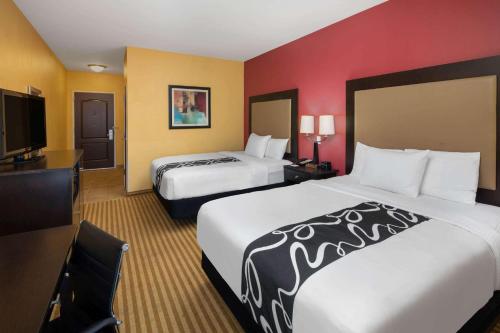a hotel room with two beds and a flat screen tv at La Quinta by Wyndham Atlanta Union City in Union City