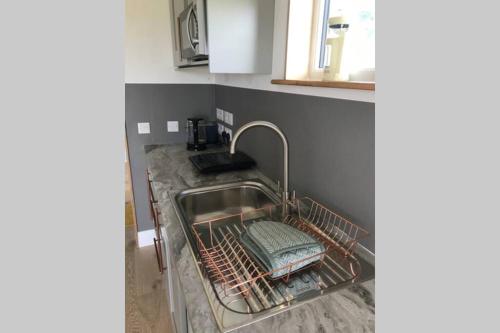 a kitchen sink with a dish drying rack in it at The Hideaway in Orbost