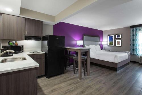 a hotel room with a bed and a kitchen with a table at La Quinta by Wyndham Effingham in Effingham