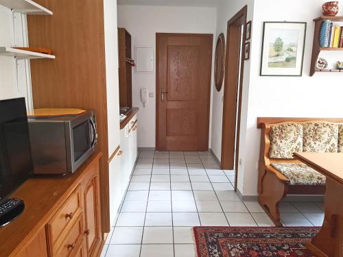eine Küche mit einem TV und eine Tür mit einer Etage in der Unterkunft Ferienwohnung Schwinghammer in Aschau im Chiemgau