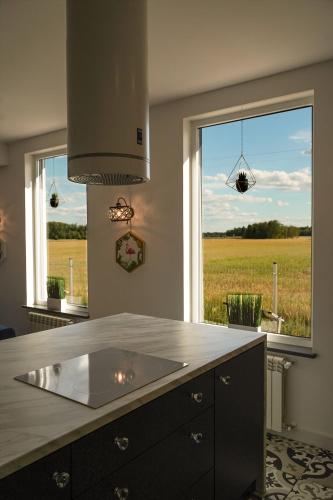 a kitchen with a large window with a view of a field at Grand House 47 in Boguszyn