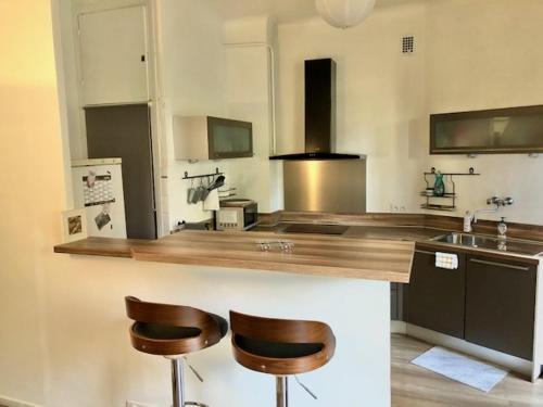 une cuisine avec deux tabourets de bar et un comptoir dans l'établissement Appartement NICE proche MER et CENTRE, à Nice