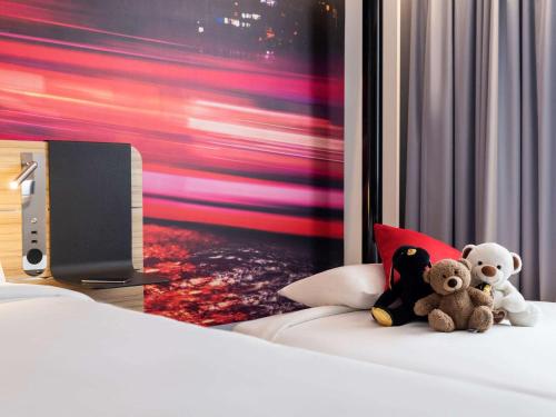 two teddy bears sitting on a bed in a hotel room at Novotel Bordeaux Centre Ville in Bordeaux