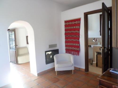 a living room with a chair and a fireplace at Cortijo Los Malenos in Agua Amarga
