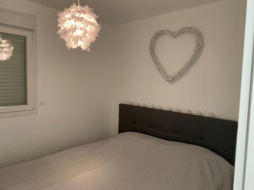 a bedroom with a heart shaped mirror on the wall at Les lodges du chateau in Marquise