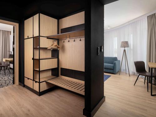 a living room with a closet with a blue couch at Mercure Warszawa Ursus Station in Warsaw