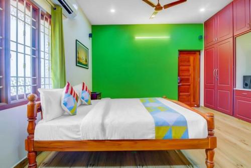 a bedroom with a green wall and a bed at Paradise Home Stay Pondicherry Luxury Stay with Private Swimming Pool in Auroville