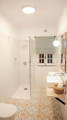 a bathroom with a shower and a toilet and a sink at Casa Branca in Ericeira