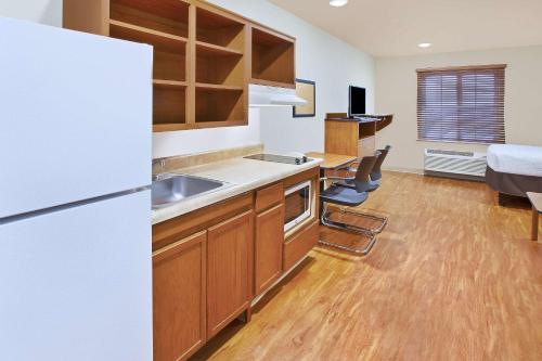a kitchen with a sink and a refrigerator in a room at WoodSpring Suites Columbus Urbancrest in Grove City