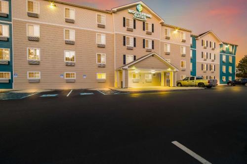 a hotel with a parking lot in front of it at WoodSpring Suites | North Charleston Airport I-526 in Charleston