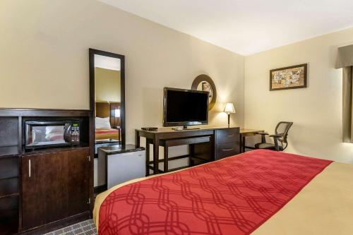 a hotel room with a bed and a desk with a television at Econo Lodge Brunswick Travel Center in Brunswick
