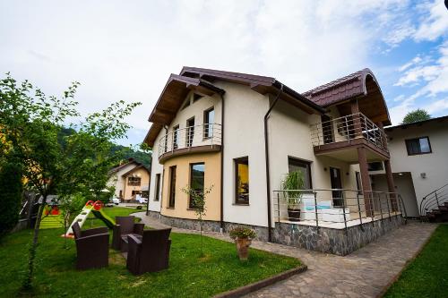 a house with a grass yard in front of it at Casa Perla Nordului in Moisei