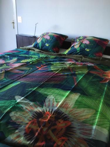 a bed with a colorful comforter on it at Villa Amoulogies in Amougies