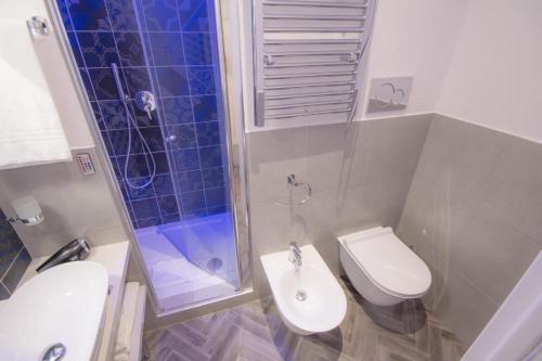 a bathroom with a toilet and a shower and a sink at Frattina FF italian suites in Rome