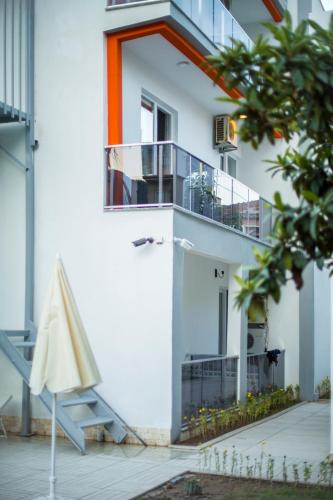 a white building with a balcony and a staircase at Belsun Hotel in Beldibi