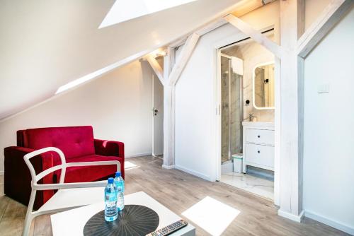 - un salon avec une chaise rouge et une table dans l'établissement Apartment Zamojska 8 - Apartamenty GKM Lublin, à Lublin