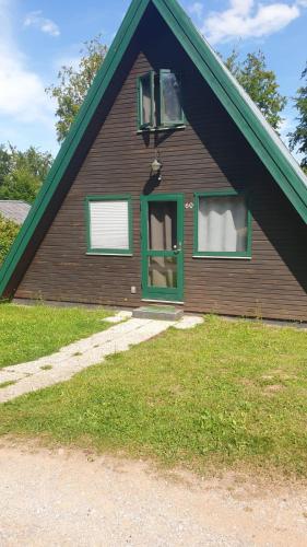 una casa con una puerta verde y dos ventanas en Ferienhaus Nr. 60 Im Ferienpark am Twistesee, en Bad Arolsen