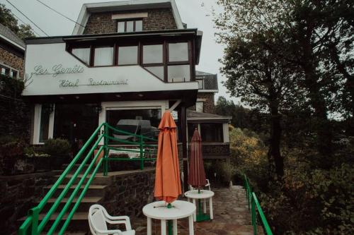 two umbrellas sitting on tables in front of a building at Les Genêts in La Roche-en-Ardenne