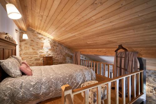 um quarto com uma cama e um tecto de madeira em Casa Fonte da Mina no Fundão