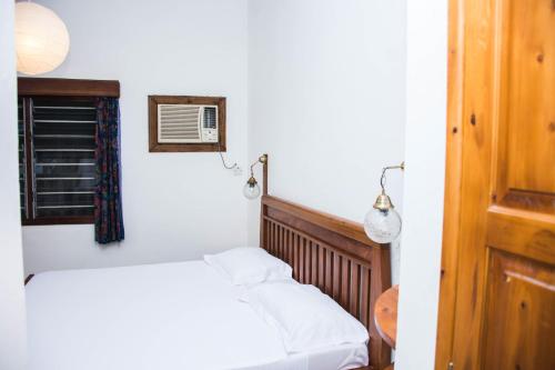 a small bedroom with a bed and a window at Baobab Village One Bedroom apartment - Type I in Dar es Salaam
