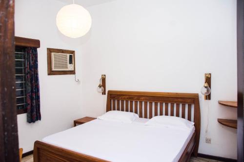 1 dormitorio con 1 cama con sábanas blancas en Baobab Village One Bedroom apartment - Type I, en Dar es Salaam