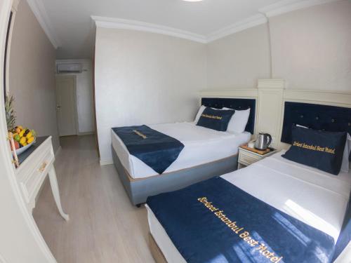 two beds in a small room with blue and white at Seher HOTEL in Istanbul