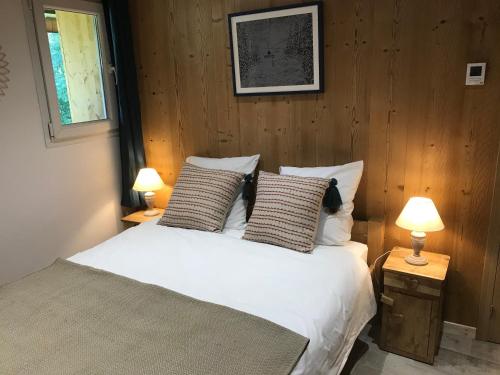 - une chambre avec un lit blanc et deux lampes dans l'établissement La Maison du Hérisson, à Samoëns