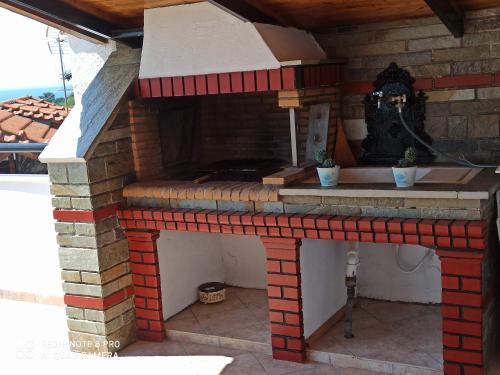 an outdoor kitchen with a brick oven on a patio at Olympus and Sea View Apartments in Nea Michaniona
