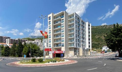 un grande edificio bianco di fronte a una strada di Apartments Alme a Budua