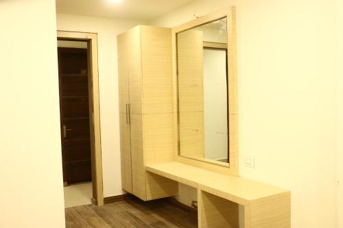 a bathroom with a wooden vanity and a mirror at lords residency in Bhopal